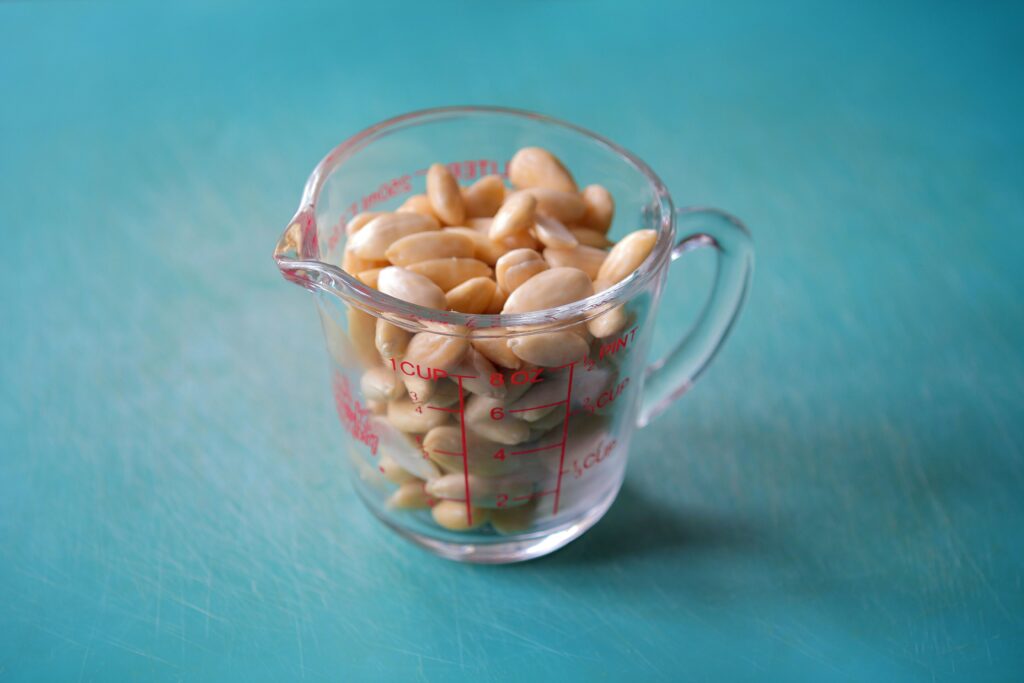 A measuring cup full of peanuts.