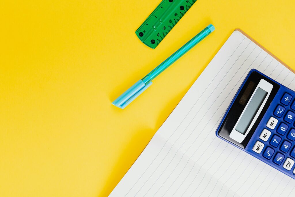 A calculator, notebook, pen and ruler as tools like the scale.