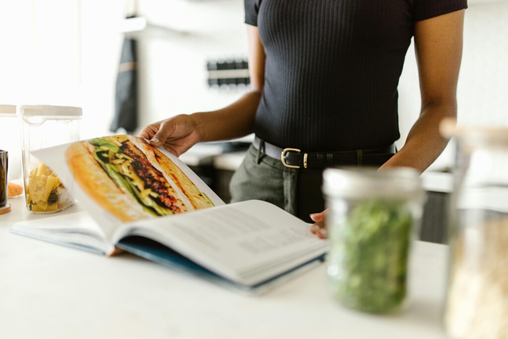 A person in the the kitchen reviewing a recipe.