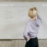 A person doing math on a whiteboard.