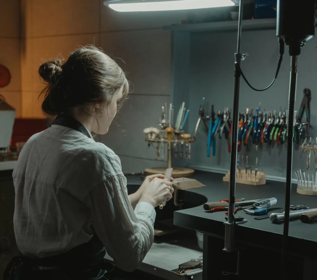 A craft person working at a bench.